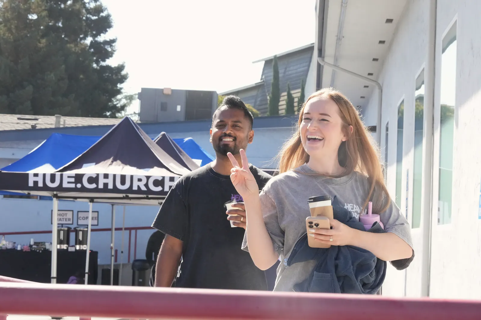 Two people smiling with coffee outside Hue.Church on October 18, 2026
